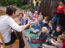 Parent Alison playing guitar to the kids